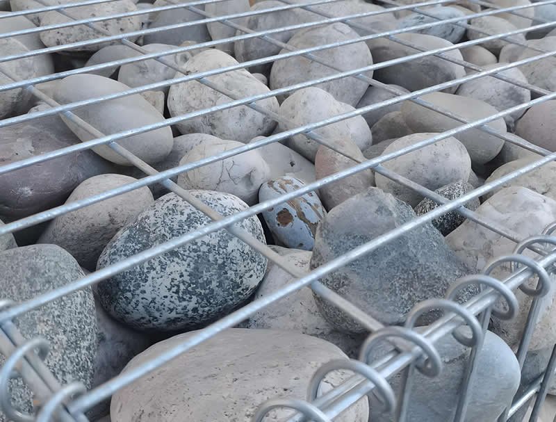 Stone-filled gabions for industrial fences offer security and noise reduction.